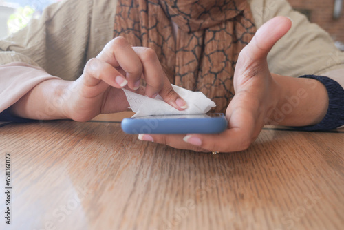 women cleaning mobile phone display for preventing virus 