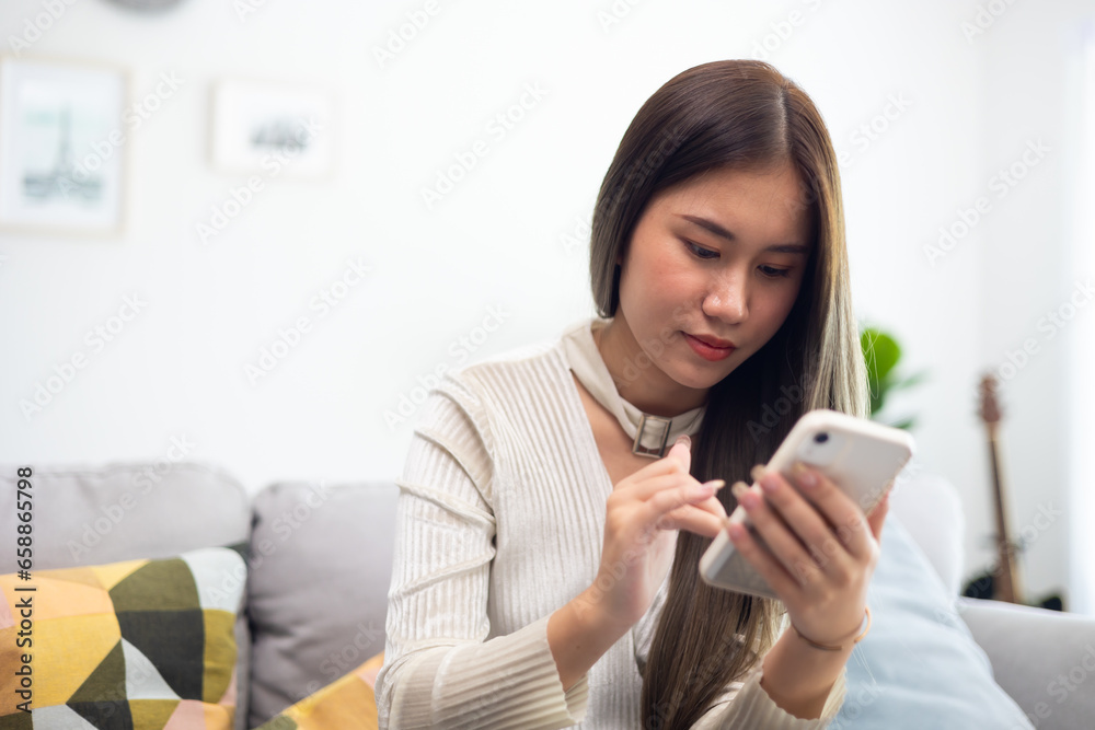 Relaxing and enjoy weekend. Asian thai young woman wear casual use mobile phone or cellphone, relax on sofa at home Relaxing and enjoy weekend. Asian thai young woman wear casual use mobile phone or cellphone, relax on sofa at home