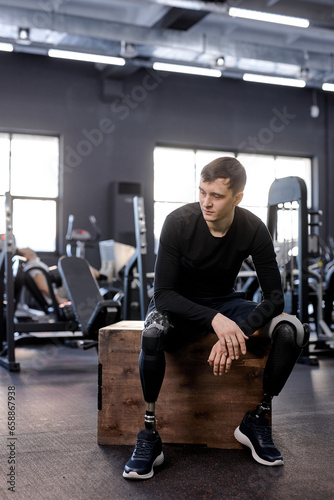young handsome brunette man in black sportswear has rest after hard workout, full length photo. rest. guy takes break