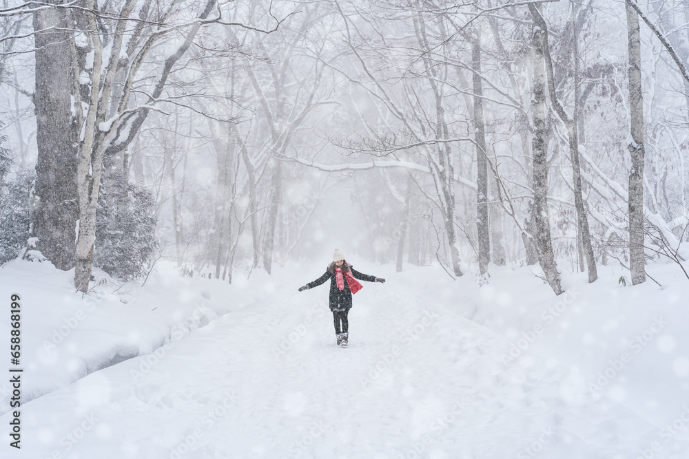 Young woman traveler enjoying with snowfall in winter