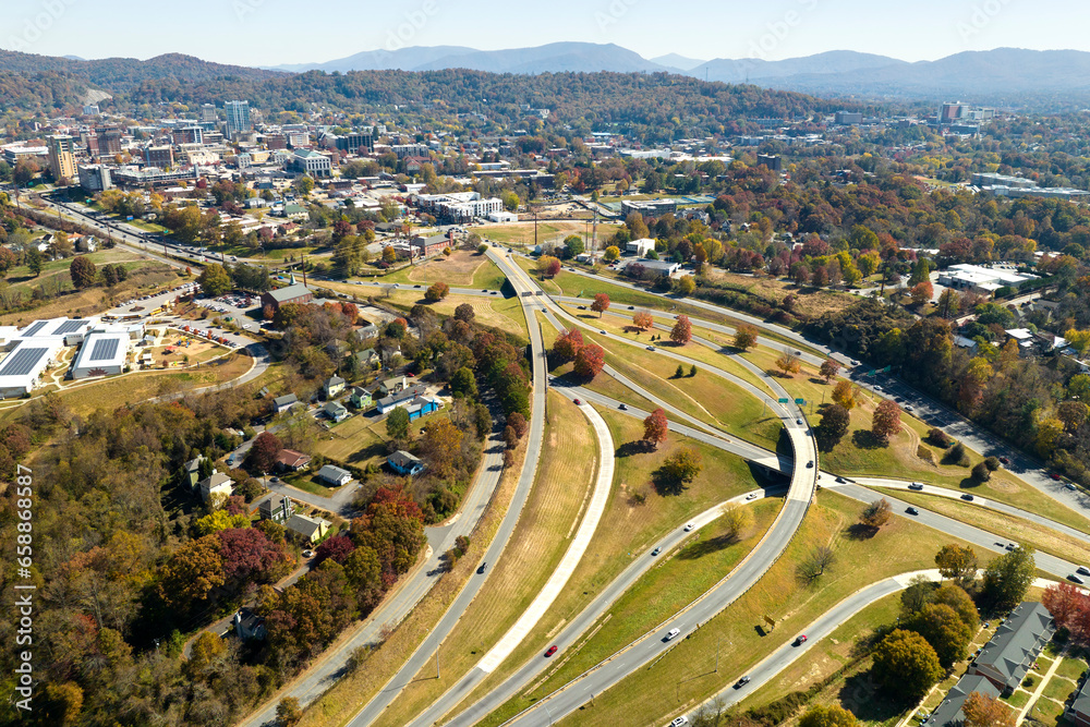 American freeway intersection in Asheville, North Carolina with fast driving cars and trucks in autumnal season. View from above of USA transportation infrastructure