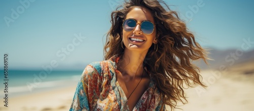 Sunglasses held by woman on stunning beach With copyspace for text