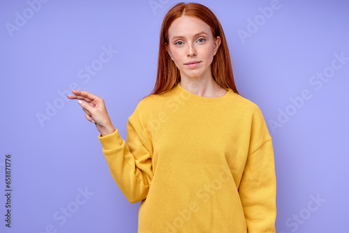 beautiful redhead serious girl, teacher showing letter P on blue background. Sign language alphabet. free education for deaf children