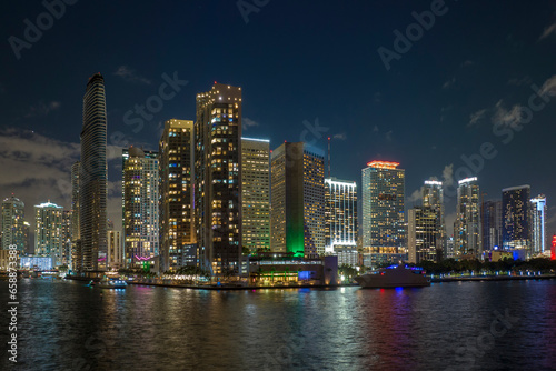 View from above of brightly illuminated high skyscraper buildings in downtown district of Miami Brickell in Florida, USA. American megapolis with business financial district at night
