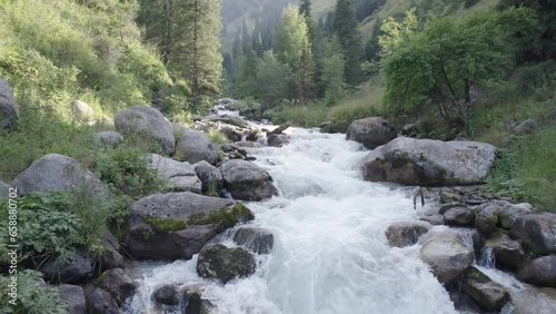 Aerial shot of flying above the stormy mountain river