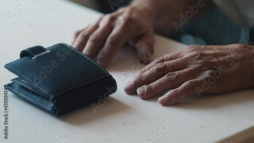 the old man's wallet and hands are on the table. concept bankruptcy, lack of money in old age. financial pension expenses, debt obligations in old age