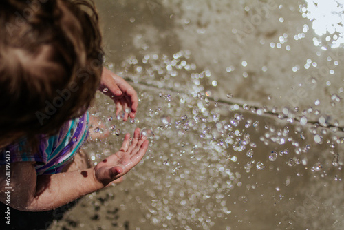 Water splashing on toddlers hands outside