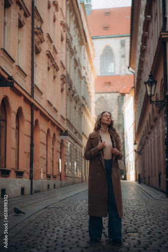 A young woman walks in the morning in sunny Prague