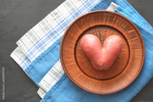 heart-shaped potatoes on a bowl, top view, flat lay. preference natural products. photo