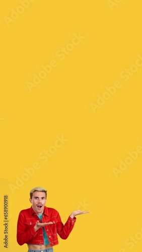 Surprised gay man pointing a blank space aside