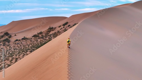 Man walking on the dune of the desert