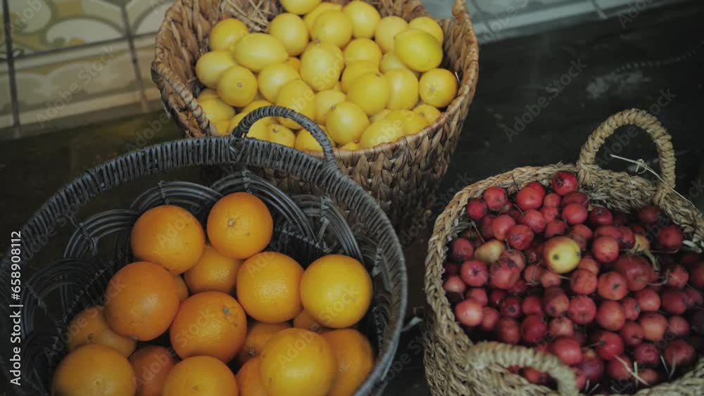 Close-up fruit in baskets.Oranges, lemons and apples in different baskets, slow motion. Close-up fruit in baskets.Oranges, lemons and apples in different baskets, slow motion.