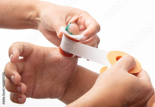 The doctor bandages his finger on his hand isolated white background