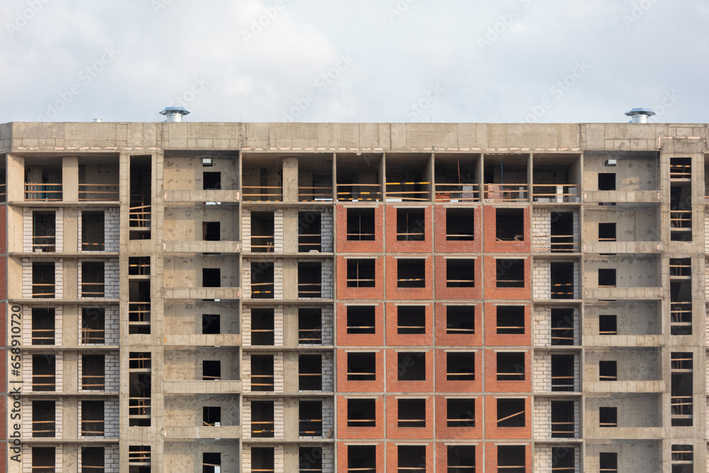 The walls of a multi-story building under construction as a background. Texture The walls of a multi-story building under construction as a background. Texture