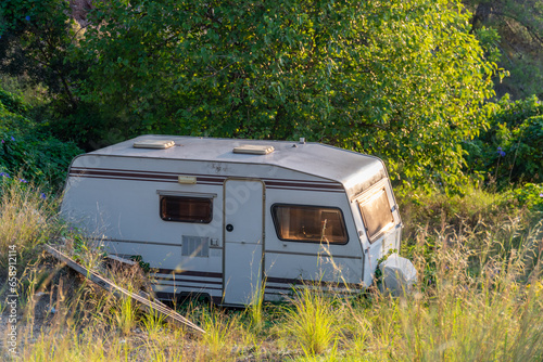 Old caravan abandoned in the field