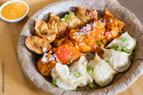A plate of assorted chicken momos (steamed, fried and chilli sauce dumplings) served on a leaf plate at Tapari Nights, a Nepalese restaurant in Auburn, Sydney - NSW, Australia