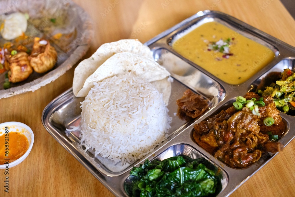 Chicken daal baht power (rice, spinach, lentil, pickle & chicken curry) served on a stainless steel tray at Tapari Nights, a Nepalese restaurant in Auburn - Sydney, New South Wales, Australia 