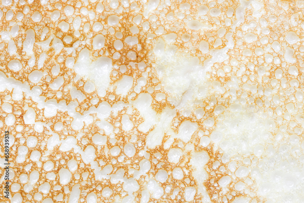 Pancake texture. Baked dough air bubbles. Food macro closeup. Fluffy pancake structure. Bubbles pattern. Spotted structure. Crepe background. Fried golden color. Pancake texture. Baked dough air bubbles. Food macro closeup. Fluffy pancake structure. Bubbles pattern. Spotted structure. Crepe background. Fried golden color.