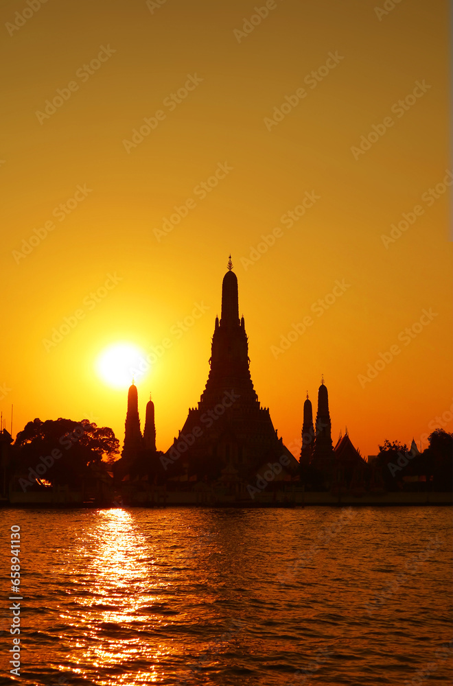 Obraz premium Bright Sun Shining over the Silhouette of Temple of Dawn or Wat Arun, One of the Best Known Landmarks of Thailand