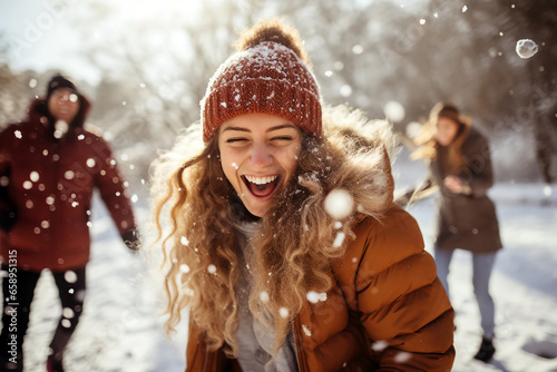 friends having fun in snow - happy friends fighting with snowballs outdoors in winter - lifestyle concept with guys and girls enjoying sunny day