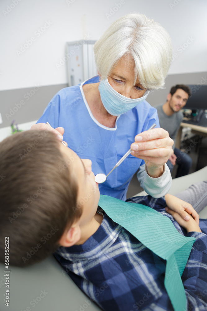 dentist examining little boys teeth in clinic dentist examining little boys teeth in clinic