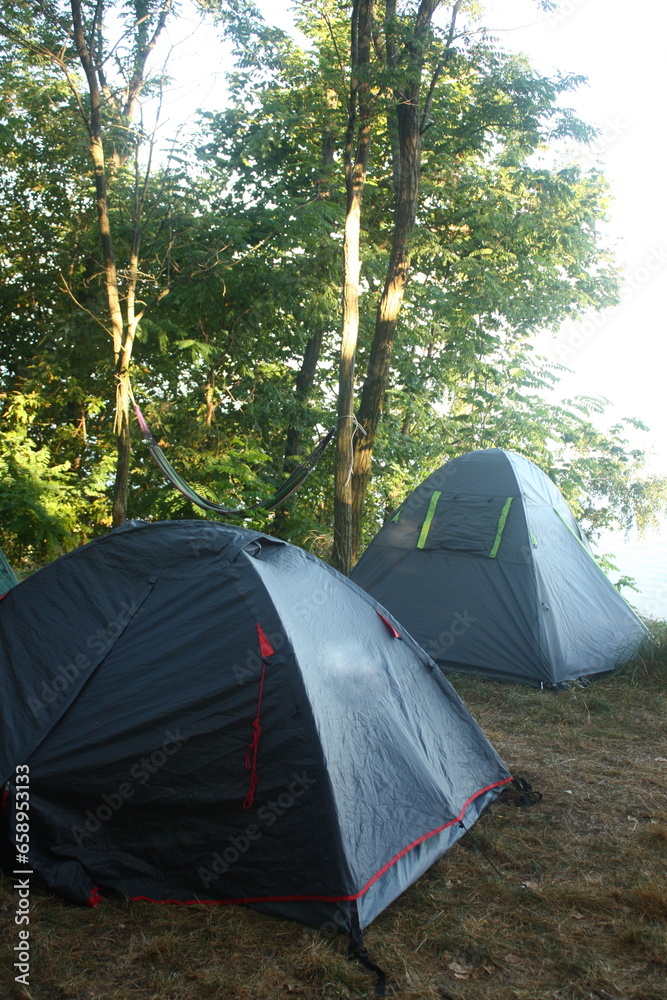 two tourist tents on the bank of the river, camping