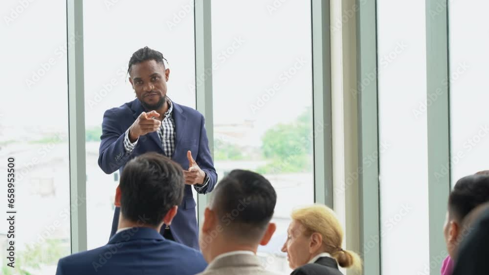 group of diversity business people clapping hands to african american business man standing and talking in font of meeting at seminar. black speaker giving lecture at a business seminar group of diversity business people clapping hands to african american business man standing and talking in font of meeting at seminar. black speaker giving lecture at a business seminar