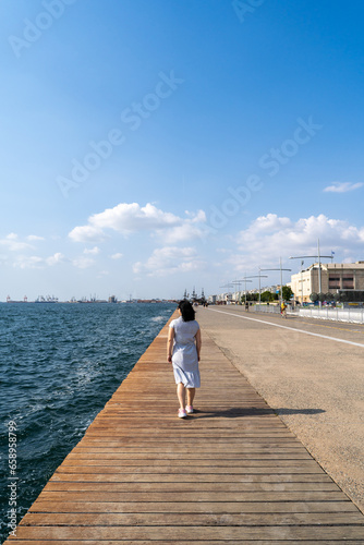Woman Walking Alone On Thessaloniki Promenade By The Sea