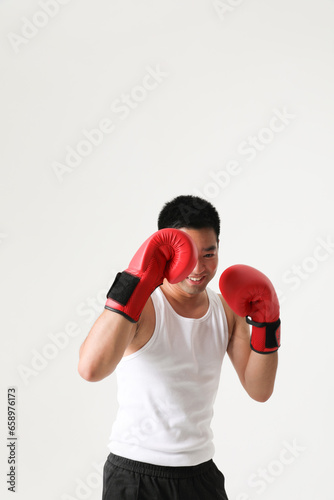 Energetic young south-asian boxer man wearing red gloves. Vertical mock-up.