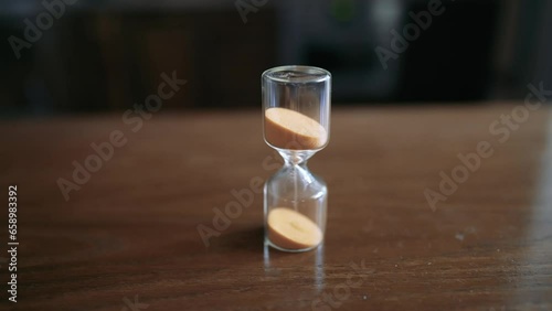 The timelapse pours sand in an hourglass. Time is running out fast. Stop time and start it back. A man's hand turns over an hourglass.