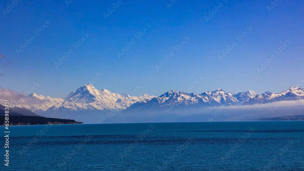 The mountain view of  alpine as snow-capped mount peaks and blue lake in Winter mountains, panorama scene