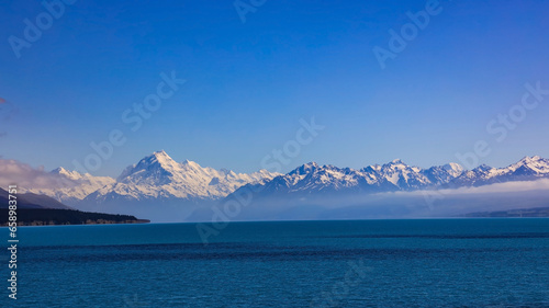 The mountain view of  alpine as snow-capped mount peaks and blue lake in Winter mountains  panorama scene