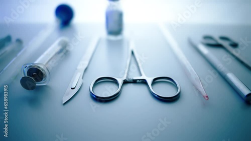 Medical instruments in steel tray on table for surgery. Preparing of surgical tools for a operation. Scalpels and forceps and tweezers. Surgery or emergency case and ambulance or treatment concept.