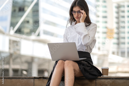 Success businesswoman sitting on stairway using computer laptop connect remote office. Female employee sit on stair working online outside workplace, reading message via wireless technology connection