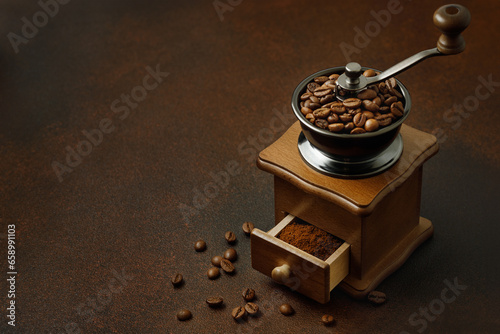 Fotografie coffee grinder with roasted beans on the brown table