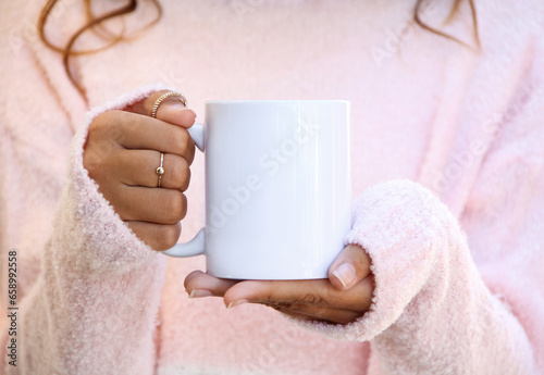 Girl is holding blank white porcelain mug in hands and soft pink sweater. Blank 11 oz ceramic cup

