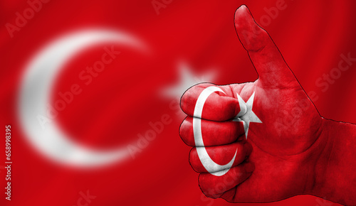 thumbs up in approval with the Turkish flag painted