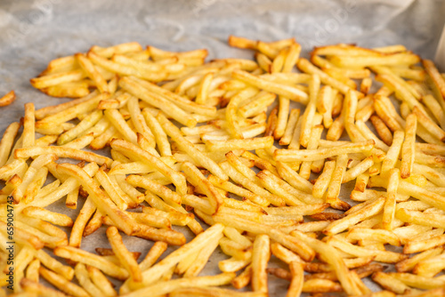 fried french fries lying on baking paper. Cooking frozen French fries in the oven