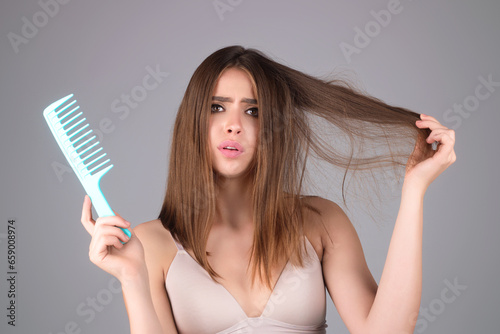 Sad woman with hair loss problem worried about hairloss. Messy bed hair. Problem with tangled hair. Worried girl with damaged hair. Hairloss problem. Portrait of woman with a comb and bad hairs.