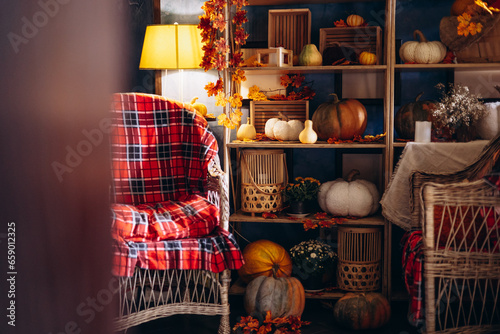 Pumpkin decorations with hay, baskets, and cozy chair place © Petro