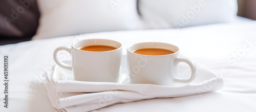 Hotel room with twin welcome coffee cup on white bed concept of hospitality and travel