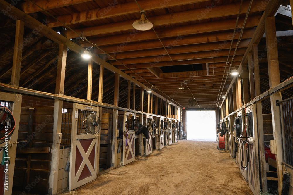 Interior shot of wooden horse stable with stalls inside the barn Interior shot of wooden horse stable with stalls inside the barn