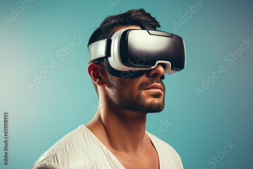 Portrait of an attractive man on the side wearing virtual reality goggles on a blue background.