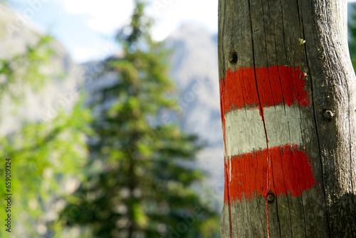Close up of a red and white road marking on an alpine mountain trail 