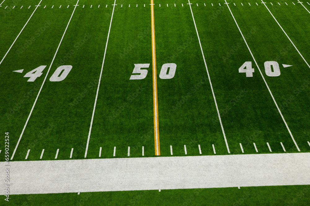 Obraz premium Football 50 Yard Line with yellow stripe and green artificial turf