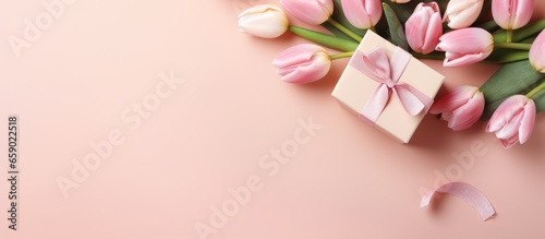 Mother s Day decorations top view of gift boxes ribbon bows tulips on pastel pink background with copyspace © AkuAku