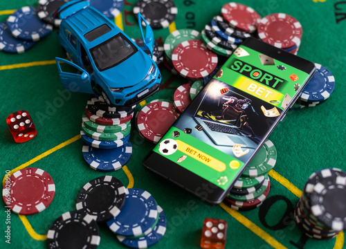 pile of casino chips and toy car, smartphone with betting on sports
