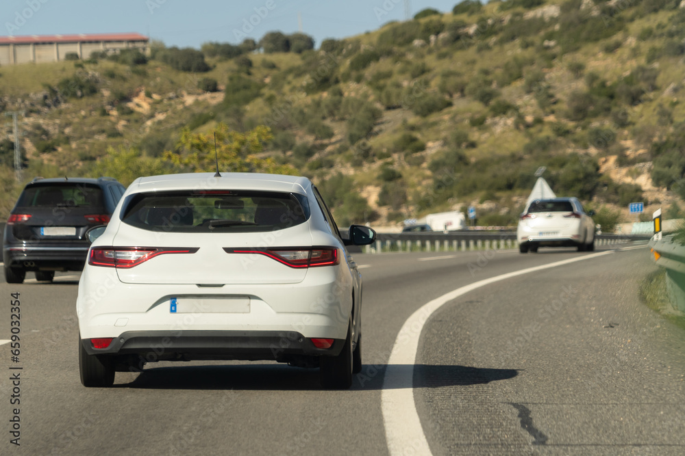 cars driving on a Spanish highway with three lanes and modern cars cars driving on a Spanish highway with three lanes and modern cars