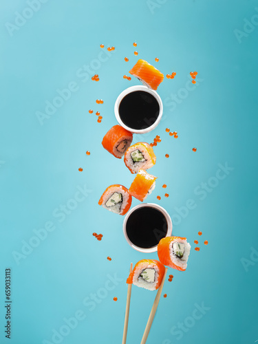 food photography of flying sushi rolls Philadelphia with salmon and soya sauce . Creative levitation concept 