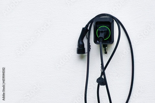 Isolated close-up of wall EV charger. Recharging sustainable transport at home. EV charger in a residential house. Clean power. Future transport technology. photo